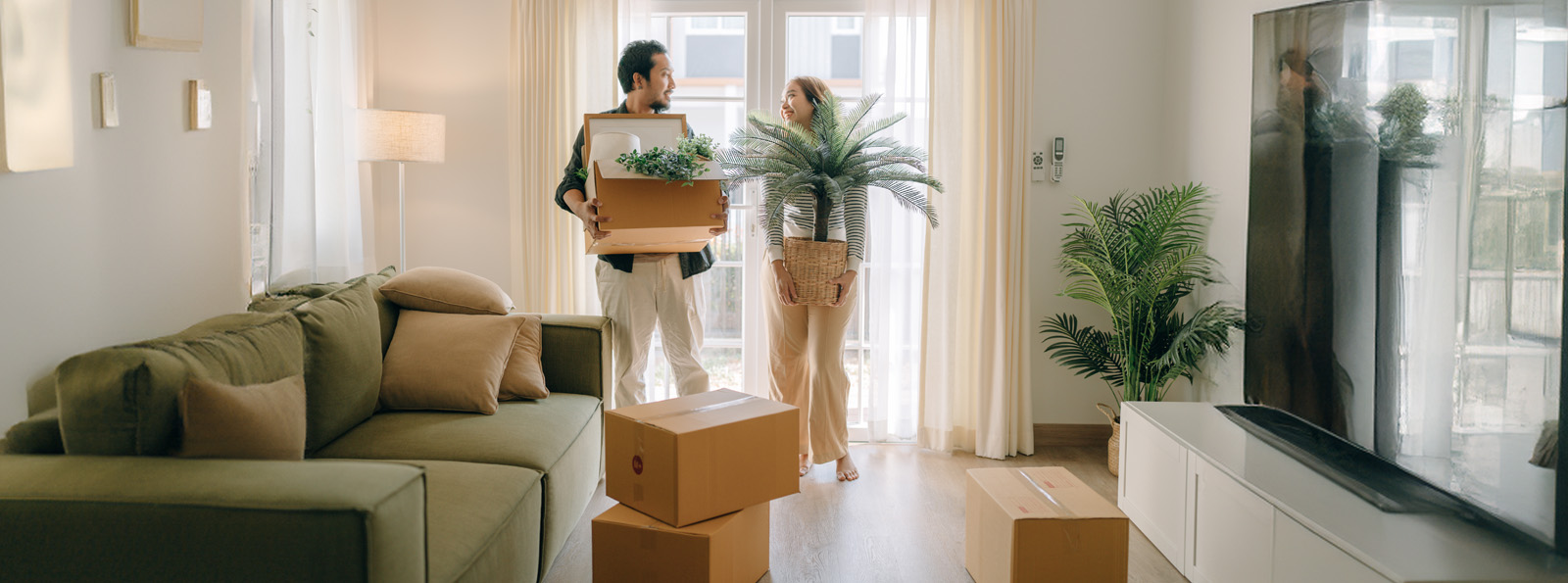 A couple carries their belongings into their new home on move-in day