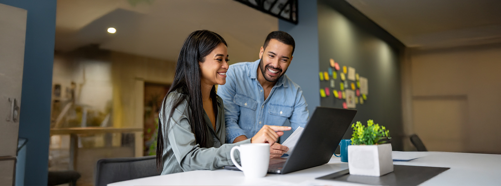 Man and woman looking at a laptop together in an office