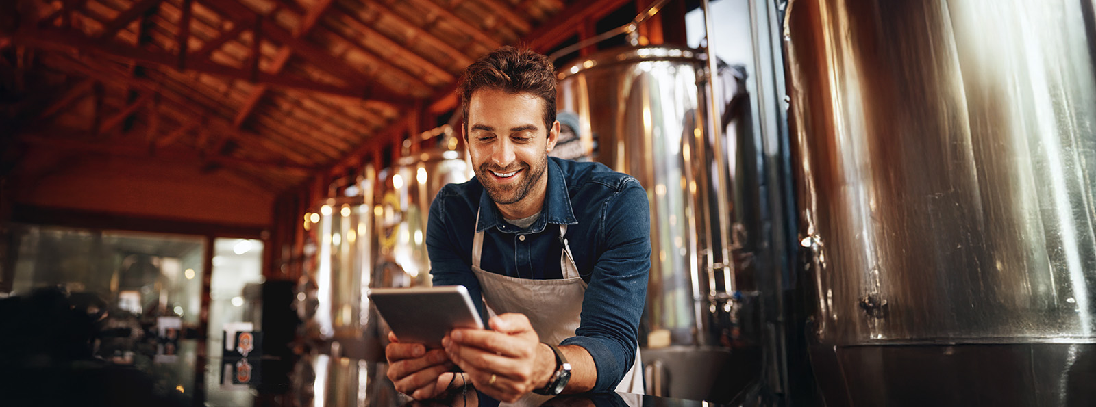 Young man holding a tablet in a distillery