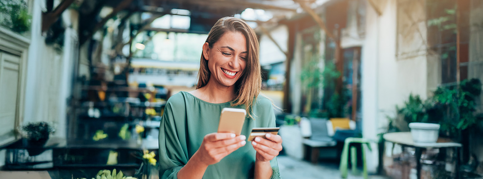 Young Woman Looking at smart phone and a credit card