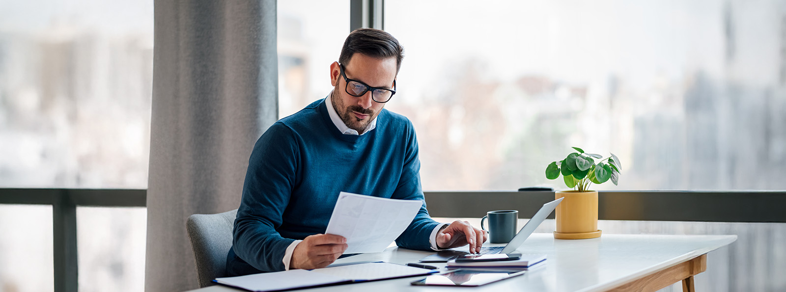 Man sitting at a desk is looking at a document